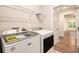 Bright laundry area features modern appliances and convenient shelving, leading to the rest of the house at 3919 Shelleydale Dr, Powder Springs, GA 30127