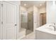 Well-lit bathroom showcasing the tiled shower, double vanity, and walk-in closet access at 3919 Shelleydale Dr, Powder Springs, GA 30127