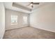 Spacious primary bedroom featuring a tray ceiling, neutral carpet, and natural light at 3919 Shelleydale Dr, Powder Springs, GA 30127