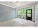 An empty, sunlit sunroom featuring large windows and an exit door providing access to the outdoors at 3919 Shelleydale Dr, Powder Springs, GA 30127
