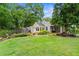 Spacious backyard featuring lush green grass, lovely landscaping, and fenced-in yard with a wooded perimeter at 574 Chicasaw Ne Dr, Marietta, GA 30060