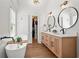 Bathroom boasts a dual sink vanity and soaking tub with hardwood floors and modern fixtures at 574 Chicasaw Ne Dr, Marietta, GA 30060