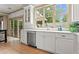 Bright kitchen featuring white cabinetry, stainless steel appliances, quartz countertops, and a large window view at 574 Chicasaw Ne Dr, Marietta, GA 30060