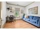 Home office with a desk, blue sofa, natural light, and wood floors for a productive workspace at 574 Chicasaw Ne Dr, Marietta, GA 30060