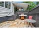 Outdoor patio features a grill, stone floor, stairs, wooden fence, and a red chair and table at 574 Chicasaw Ne Dr, Marietta, GA 30060