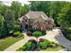 A bird's eye view of the brick and stone house with circular driveway and manicured front yard at 8340 Colonial Pl, Duluth, GA 30097