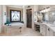 Serene bathroom featuring a soaking tub, walk-in shower, and elegant vanity with natural light at 8340 Colonial Pl, Duluth, GA 30097