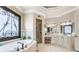 Elegant bathroom featuring a soaking tub, glass shower, and dual vanities with decorative accents at 8340 Colonial Pl, Duluth, GA 30097