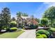 Stunning brick and stone home with manicured landscaping and a circular driveway at 8340 Colonial Pl, Duluth, GA 30097