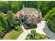 An aerial view of an estate with a circular driveway and verdant landscaping at 8340 Colonial Pl, Duluth, GA 30097