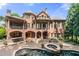 View of a brick home, outdoor bar, and a large pool with a stone-trimmed hot tub at 8340 Colonial Pl, Duluth, GA 30097