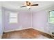 Bedroom with hardwood floors, two exterior windows, and bare lilac-painted walls at 2054 Fargo Se Pl, Atlanta, GA 30316