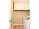 Functional laundry room with overhead cabinets, clean white washer, and laminate wood-look flooring at 3112 Calumet Nw Cir, Kennesaw, GA 30152