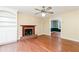 Cozy living room with a brick fireplace, hardwood floors, and built-in shelving at 3112 Calumet Nw Cir, Kennesaw, GA 30152