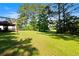 Expansive backyard with lush green grass and mature trees, perfect for outdoor activities at 405 Branch Forest Way, Stockbridge, GA 30281