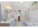 Bright bathroom featuring dual sinks, a large mirror, and a glass-enclosed shower and tub at 405 Branch Forest Way, Stockbridge, GA 30281
