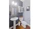 Cozy half-bath featuring stylish fixtures, a pedestal sink, and decorative mirror at 405 Branch Forest Way, Stockbridge, GA 30281