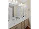 This bright bathroom features a double sink vanity with framed mirrors, great lighting, and neutral decor at 405 Branch Forest Way, Stockbridge, GA 30281