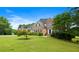 Traditional brick home boasts a lush green lawn and mature landscaping, offering great curb appeal at 405 Branch Forest Way, Stockbridge, GA 30281