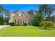 Traditional brick home with well-manicured landscaping and a lush green lawn offers a welcoming curb appeal at 405 Branch Forest Way, Stockbridge, GA 30281