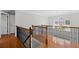 Upstairs hallway with wood floors and wrought iron banister overlooking front yard at 405 Branch Forest Way, Stockbridge, GA 30281