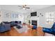 Cozy living room with hardwood floors, a fireplace, and large windows at 405 Branch Forest Way, Stockbridge, GA 30281