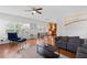 Open living space features hardwood floors, neutral walls, a ceiling fan, and ample natural light at 405 Branch Forest Way, Stockbridge, GA 30281