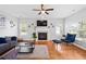 Bright living room with hardwood floors, fireplace, ceiling fan, and a comfortable seating area at 405 Branch Forest Way, Stockbridge, GA 30281