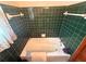 A tiled bathroom features a bathtub, white fixtures, and a window with lace curtains at 871 Malcom Se St, Conyers, GA 30012