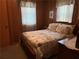 Bedroom featuring paneled walls, floral bedding, a dresser, and bedside table at 871 Malcom Se St, Conyers, GA 30012