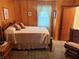 Bedroom with wood paneled walls, neutral bedding, and a rocking chair at 871 Malcom Se St, Conyers, GA 30012