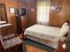 A cozy bedroom with wood paneling, a floral bedspread, and a comfortable armchair at 871 Malcom Se St, Conyers, GA 30012