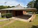 View of the home featuring a large carport, brick siding, and manicured landscaping at 871 Malcom Se St, Conyers, GA 30012