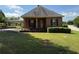 Charming single-story brick home with a manicured lawn, mature landscaping, and covered carport at 871 Malcom Se St, Conyers, GA 30012