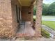 View of the front porch with a small seating area, brick columns, and decorative potted plants at 871 Malcom Se St, Conyers, GA 30012