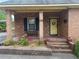 Inviting front porch with brick columns, a bench, and decorative potted plants on the brick porch at 871 Malcom Se St, Conyers, GA 30012