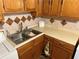 This kitchen features wood cabinets, stainless steel sink, and stylish backsplash at 871 Malcom Se St, Conyers, GA 30012