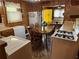 Eat-in kitchen with wood cabinetry, appliances, table, and an adjacent entry to living room at 871 Malcom Se St, Conyers, GA 30012