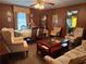Spacious living room featuring dining table, multiple seating areas, and classic wood paneling at 871 Malcom Se St, Conyers, GA 30012