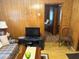 A cozy living room with wood paneling, a plaid sofa, and view into other rooms at 871 Malcom Se St, Conyers, GA 30012