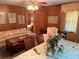 Open-concept living room featuring dining table, floral sofa, and classic wood paneling at 871 Malcom Se St, Conyers, GA 30012