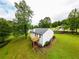 Aerial view of backyard with a large grassy area, deck, and mature trees at 1444 Elliotts Lane, Auburn, GA 30011