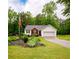 Charming single-story home with red brick accents, white siding, landscaped yard, and American flag at 1444 Elliotts Lane, Auburn, GA 30011