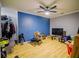 Spacious living room with blue accent wall, ceiling fan, and hardwood floors at 1444 Elliotts Lane, Auburn, GA 30011