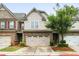 Charming townhome featuring a stone and neutral siding exterior, a two-car garage, and manicured landscaping at 1630 Marsanne Nw Ter # 27, Kennesaw, GA 30152