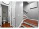 Hallway with beautiful hardwood stairs leads to a half bath, and a light wall color at 1630 Marsanne Nw Ter # 27, Kennesaw, GA 30152