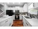 Well-lit kitchen with white cabinetry, stainless steel appliances, and an island with a marble countertop at 1630 Marsanne Nw Ter # 27, Kennesaw, GA 30152