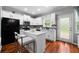 Bright kitchen features white cabinetry, stainless steel appliances, an island with seating and beautiful hardwood flooring at 1630 Marsanne Nw Ter # 27, Kennesaw, GA 30152