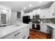 Modern kitchen featuring white cabinetry, stainless steel appliances, and an island with seating and marble countertop at 1630 Marsanne Nw Ter # 27, Kennesaw, GA 30152