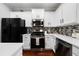 Modern kitchen with white cabinets, stainless steel appliances, and a stylish backsplash at 1630 Marsanne Nw Ter # 27, Kennesaw, GA 30152
